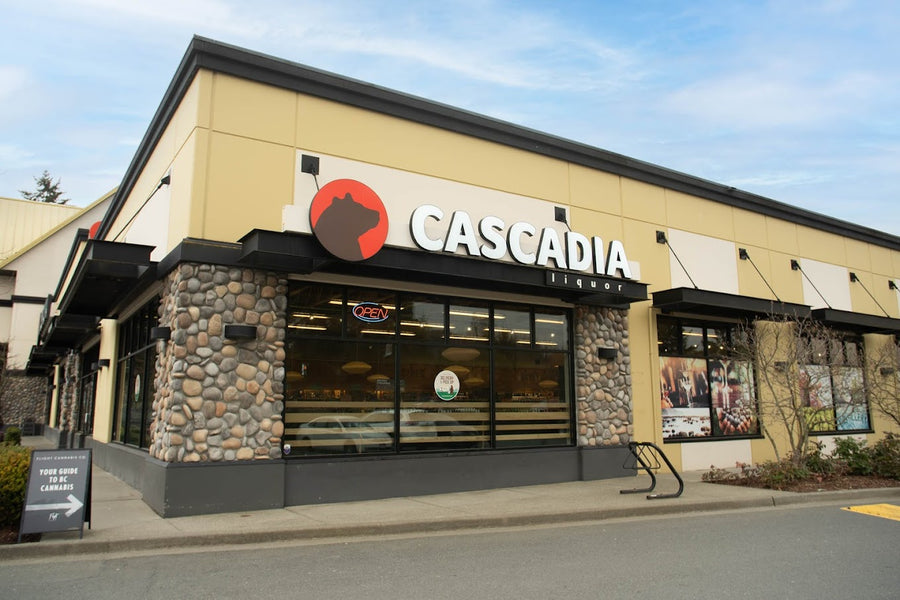 Cascadia Liquor Langford storefront featuring large windows and a stone base, with an "Open" sign visible.