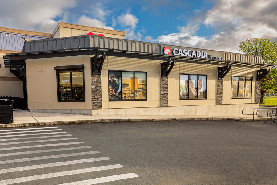 Cascadia Liquor Port Alberni storefront visible, featuring large windows and a modern design, located in an outdoor area with a cloudy sky in the background.